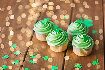 Image showing green cupcakes and shamrock on wooden table