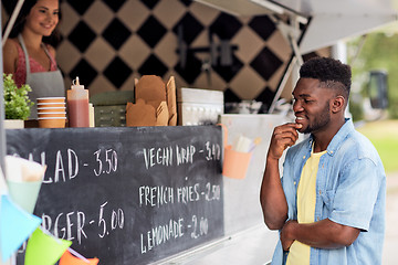 Image showing male customer looking at billboard at food truck