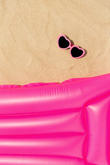 Image showing sunglasses and pink swimming mattress on beach