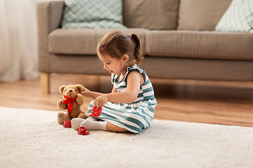 Image showing little girl playing with toy tea set at home