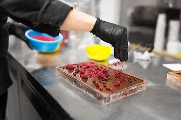 Image showing confectioner makes chocolate dessert at sweet-shop