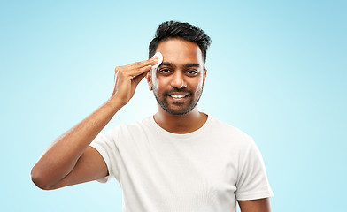 Image showing smiling indian man cleaning face with cotton pad