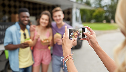 Image showing woman photographing friends eating at food truck