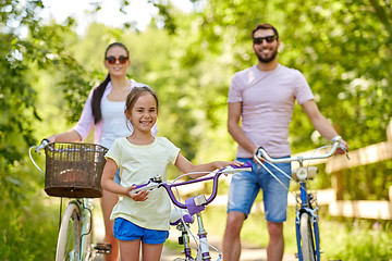 Image showing happy family with bicycles in summer park