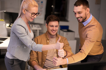 Image showing business team making thumbs up gesture at office