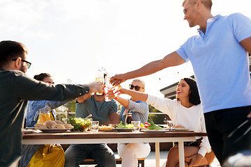 Image showing happy friends toasting drinks at rooftop party