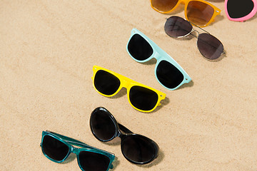 Image showing different sunglasses on beach sand