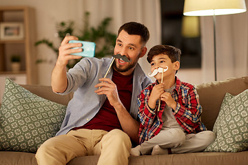 Image showing father and son taking selfie at home