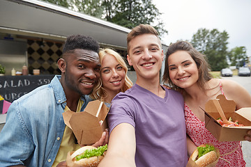 Image showing happy friends taking selfie at food truck