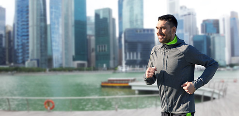 Image showing happy young man running over singapore city