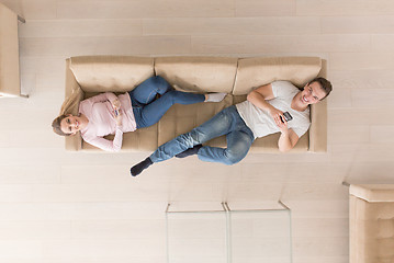 Image showing Young couple on the sofa watching television top view