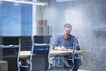 Image showing young businessman relaxing at the desk