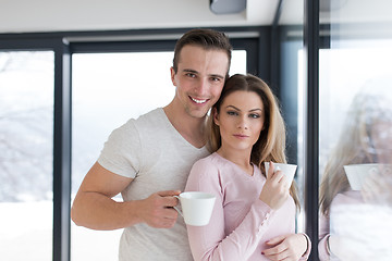 Image showing young couple enjoying morning coffee by the window