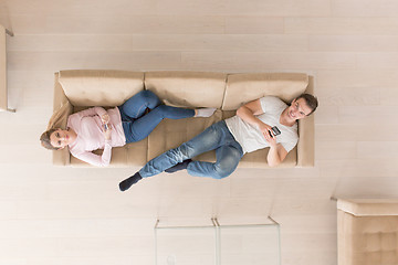 Image showing Young couple on the sofa watching television top view