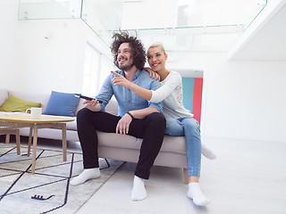 Image showing Young couple on the sofa watching television