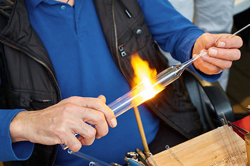 Image showing Glass master hands heat up the glass rod.