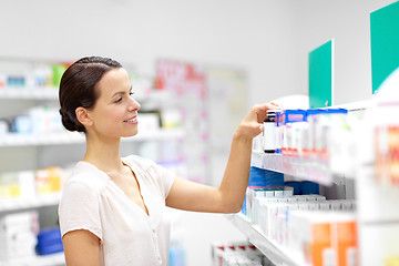 Image showing female customer choosing drugs at pharmacy