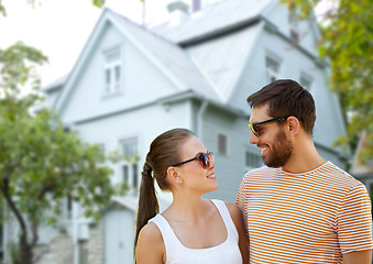 Image showing happy couple in sunglasses in summer over house