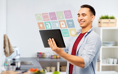 Image showing happy young man with tablet computer in kitchen