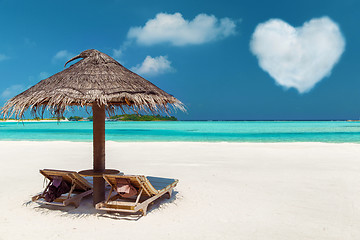 Image showing two sunbeds under palapa on maldives beach