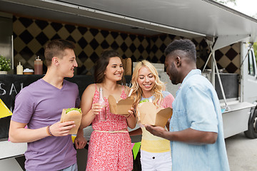 Image showing happy friends with drinks eating at food truck