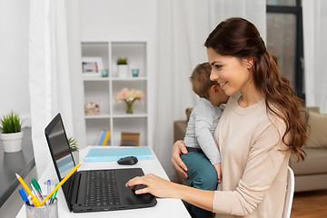 Image showing happy mother with baby and laptop working at home