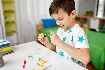 Image showing little boy playing with building kit at home