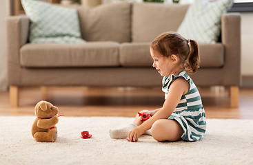 Image showing little girl playing with toy tea set at home