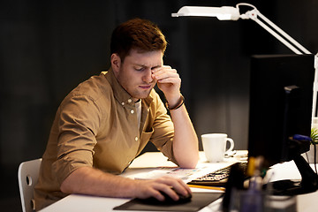 Image showing tired businessman working late at night office