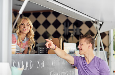 Image showing saleswoman at food truck serving male customer