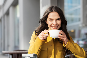 Image showing teenage girl drinking hot chocolate at city cafe