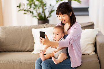 Image showing asian mother with baby son taking selfie at home