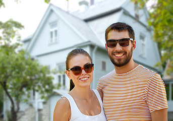Image showing happy couple in sunglasses in summer over house
