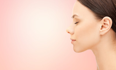 Image showing beautiful young woman face over pink background