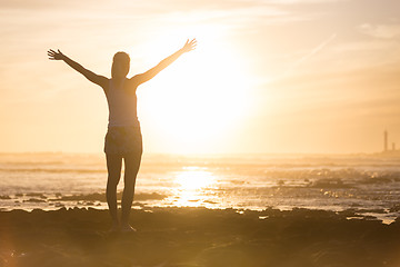 Image showing Free woman enjoying freedom on beach at sunset.