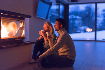 Image showing happy couple in front of fireplace