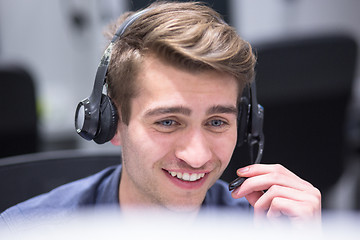 Image showing male call centre operator doing his job