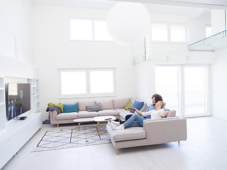 Image showing Young couple on the sofa watching television