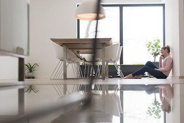 Image showing young woman using mobile phone on the floor