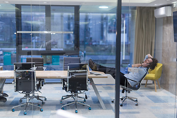 Image showing young businessman relaxing at the desk