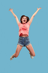 Image showing Freedom in moving. Pretty young woman jumping against blue background