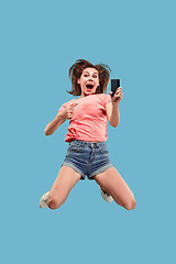 Image showing Full length of pretty young woman with mobile phone while jumping