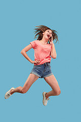 Image showing Full length of pretty young woman with mobile phone while jumping