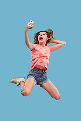 Image showing Full length of pretty young woman with mobile phone while jumping