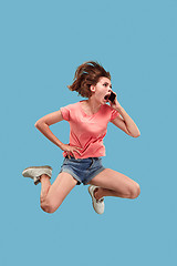 Image showing Full length of pretty young woman with mobile phone while jumping