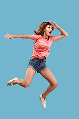 Image showing Freedom in moving. Pretty young woman jumping against blue background