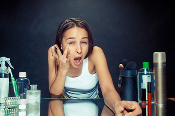 Image showing Beauty woman applying makeup. Beautiful girl looking in the mirror and applying cosmetic with a Eyeliner.