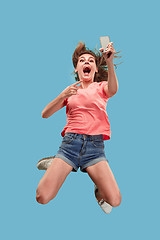 Image showing Full length of pretty young woman with mobile phone while jumping