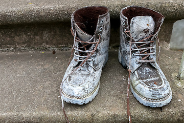 Image showing Dirty old workboots on stairs.