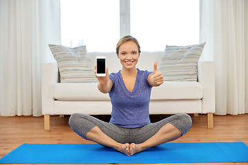 Image showing woman with smartphone doing yoga at home